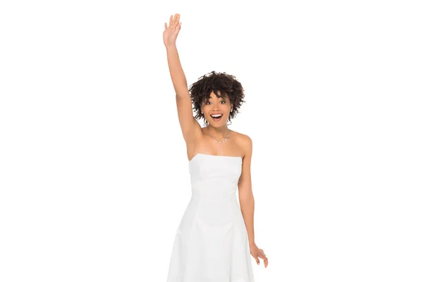 Hermosa novia afroamericana sonriendo mientras está de pie con la mano por encima de la cabeza aislada en blanco - foto de stock