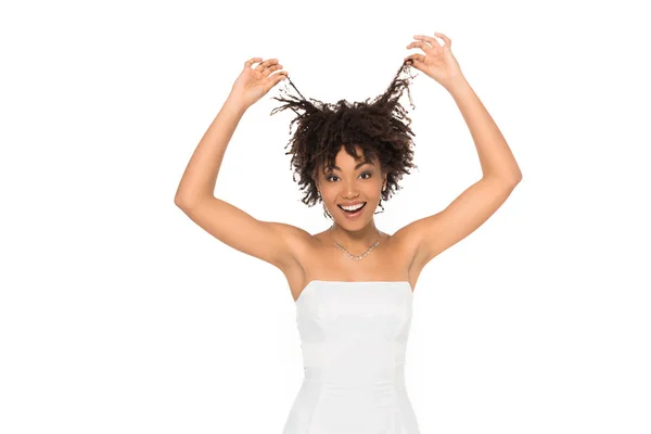 Щаслива афроамериканська наречена посміхається, торкаючись волосся ізольовано на білому — стокове фото