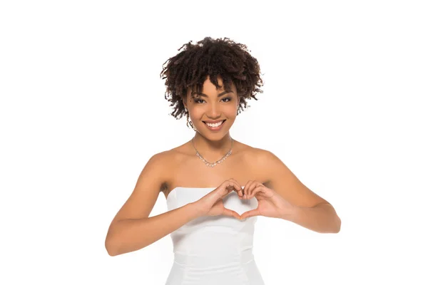 Happy and curly african american bride showing heart with hands isolated on white — Stock Photo
