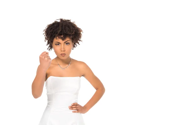 Angry african american bride showing fist and standing with hand on hip isolated on white — Stock Photo