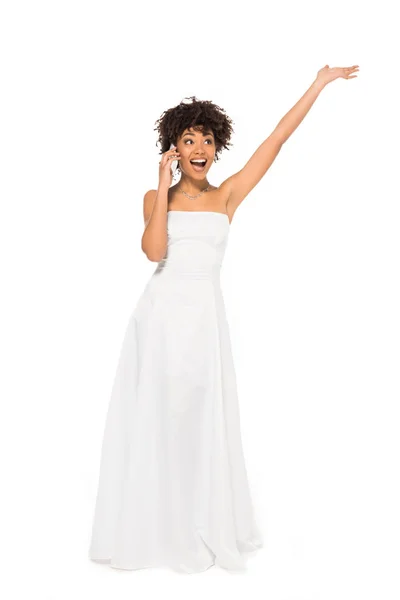 Схвильована афроамериканська наречена жестикулює і розмовляє на смартфоні ізольовано на білому — стокове фото