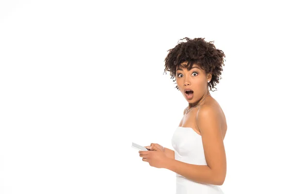 Choqué mariée afro-américaine tenant smartphone isolé sur blanc — Photo de stock