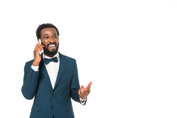 Hombre afroamericano feliz en traje hablando en teléfono inteligente aislado en blanco - foto de stock