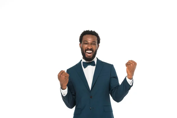 Cheerful african american bridegroom gesturing while celebrating isolated on white — Stock Photo