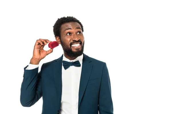 Веселий афроамериканський чоловік тримає червону коробку ізольовано на білому — стокове фото