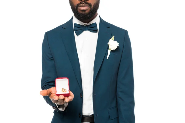 Vista cortada de barbudo homem americano africano segurando caixa com anel de casamento isolado no branco — Fotografia de Stock