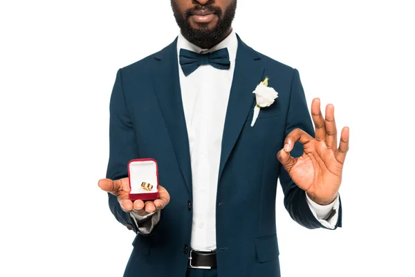 Vista recortada de la caja de espera de hombre afroamericano con anillo de boda y mostrando signo de ok aislado en blanco - foto de stock