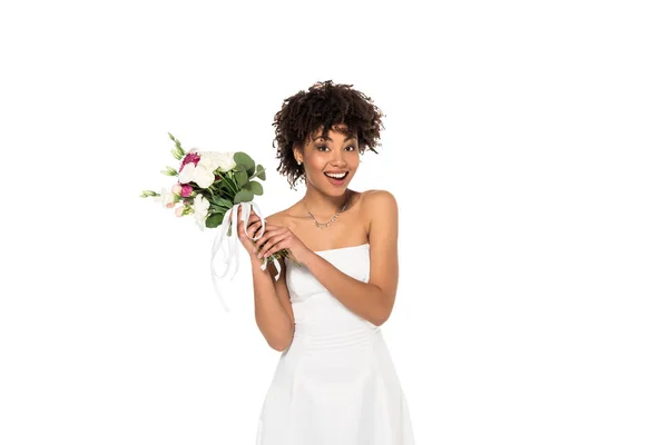 Sposa afro-americana eccitato tenendo bouquet e guardando la fotocamera isolata su bianco — Foto stock