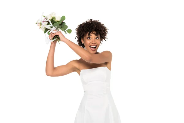 Sposa afro-americana eccitata lanciando bouquet e guardando la fotocamera isolata sul bianco — Foto stock