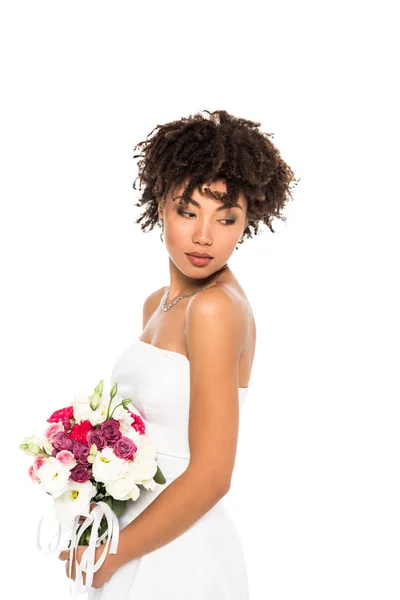 Belle fille afro-américaine en robe de mariée tenant bouquet isolé sur blanc — Photo de stock