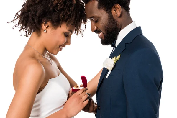 Felice donna africana americana guardando scatola rossa con anello vicino uomo allegro isolato su bianco — Foto stock