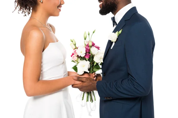 Vista recortada de la novia afroamericana feliz y novio celebración ramo aislado en blanco - foto de stock