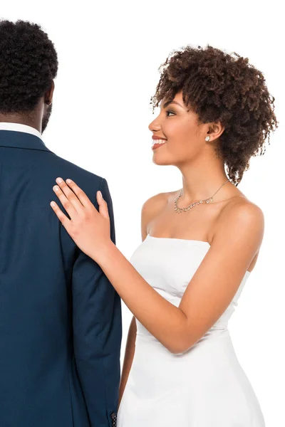 Вид ззаду афроамериканського нареченого, що стоїть біля щасливої нареченої ізольовано на білому — стокове фото