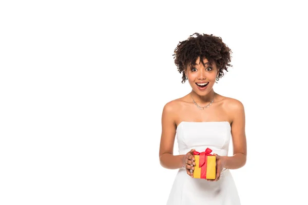 Excited african american bride holding gift box isolated on white — Stock Photo