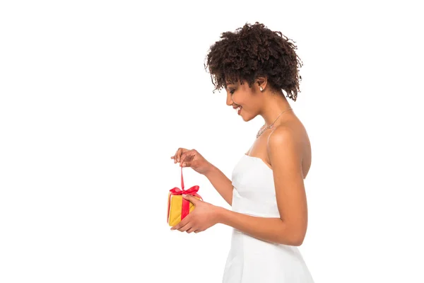 Side view of happy african american bride opening present isolated on white — Stock Photo