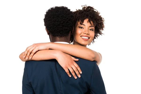 Attraente e sorridente donna africana americana abbracciare l'uomo isolato su bianco — Foto stock