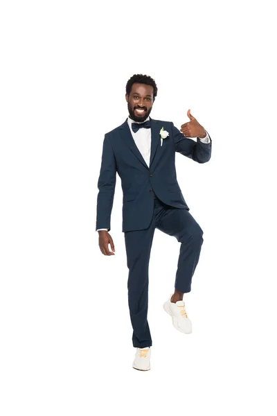 Щасливий афроамериканський чоловік у костюмі показує великий палець вгору ізольовано на білому — стокове фото