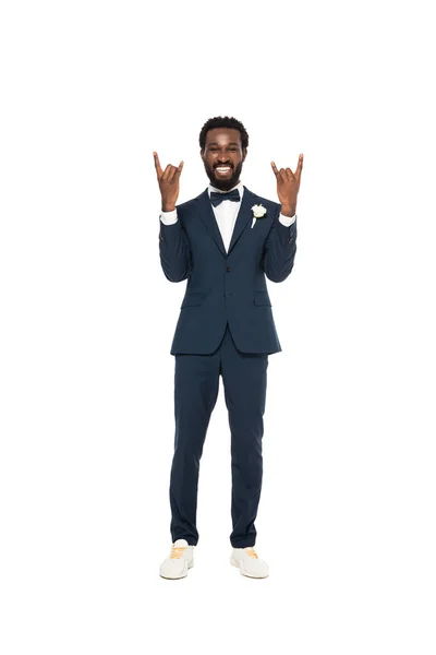 Счастливый африканский американец в костюме показывает рок-знак изолирован на белом — стоковое фото