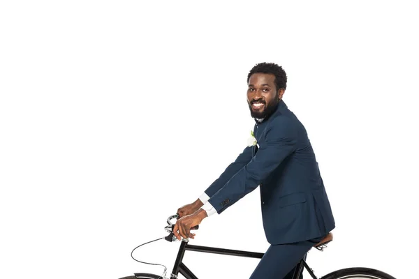 Feliz noivo americano africano andar de bicicleta e olhando para a câmera isolada no branco — Fotografia de Stock