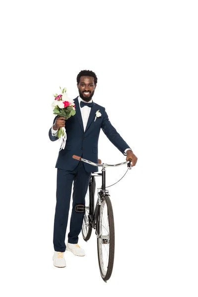 Handsome african american man holding bouquet and bicycle isolated on white — Stock Photo