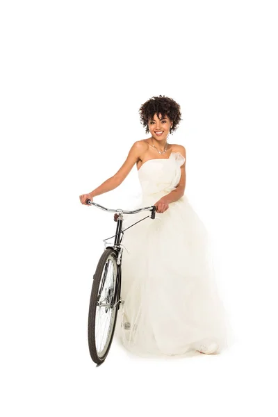 Cheerful african american bride standing with bicycle isolated on white — Stock Photo