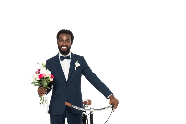 Allegro uomo afro americano in possesso di bouquet e bicicletta isolato su bianco — Foto stock