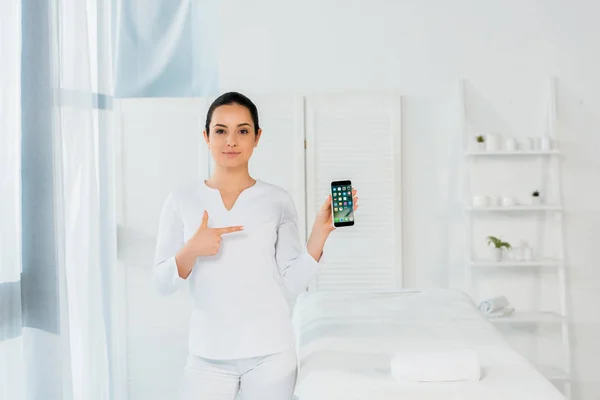 Ukraine, Kyiw - 20. Mai 2019: attraktive Frau zeigt mit dem Finger auf das iPhone — Stockfoto