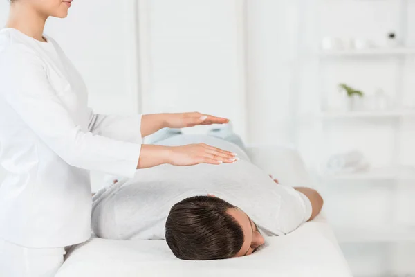 Ausgeschnittene Ansicht einer Frau, die Mann auf Massagetisch heilt — Stockfoto