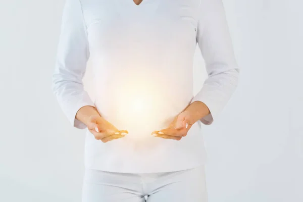 Cropped view of healer standing and gesturing near light isolated on white — Stock Photo