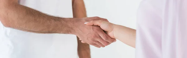 Panoramic shot of man and woman shaking hands isolated on white — Stock Photo