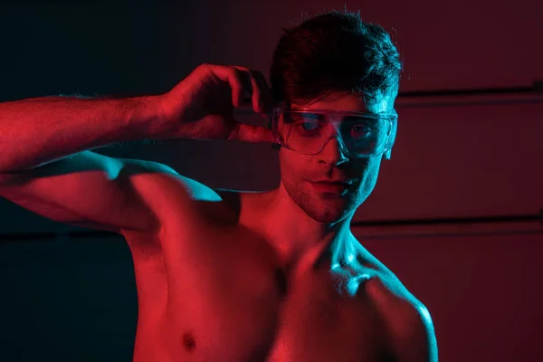 Sexy caminetto senza camicia in occhiali protettivi nel buio — Foto stock