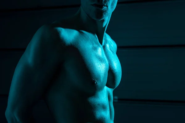 Vue recadrée de sexy homme musclé torse nu dans l'obscurité — Photo de stock