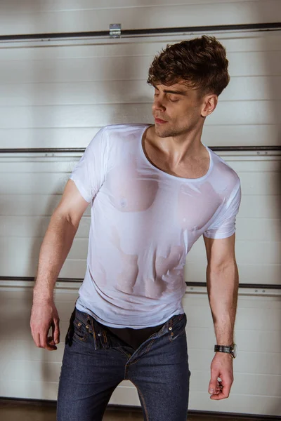 Bel homme en jeans et t-shirt blanc mouillé — Photo de stock