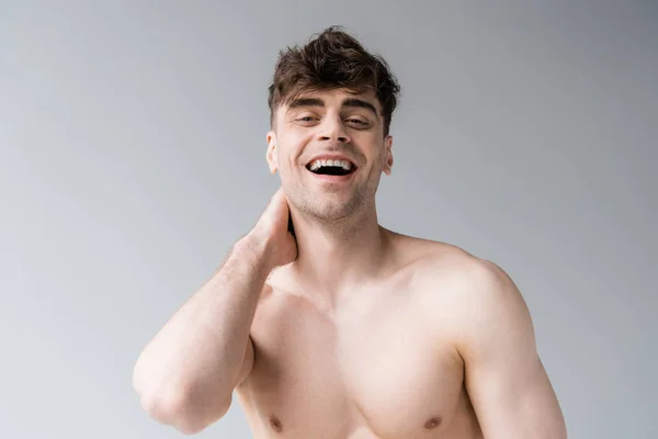 Sorridente sem camisa sexy muscular homem isolado no cinza — Fotografia de Stock