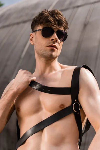 Sexy shirtless man in black sunglasses and sword belt — Stock Photo