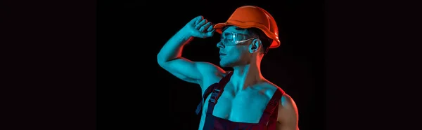 Colpo panoramico di pensoso sexy pompiere in generale e hardhat isolato su nero — Foto stock