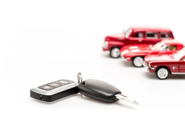 Clés et voitures jouet rouge sur surface blanche — Photo de stock