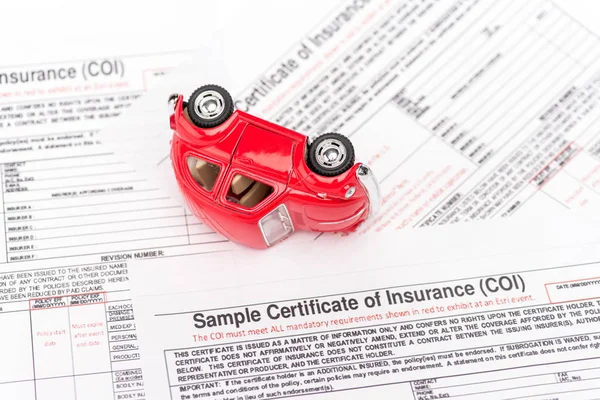 Voiture jouet rouge et documents d'assurance sur blanc — Photo de stock