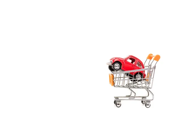 Coche de juguete rojo en carro de la compra aislado en blanco - foto de stock