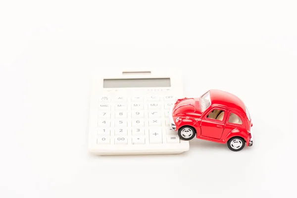 Красный автомобиль игрушки и калькулятор на белой поверхности — стоковое фото