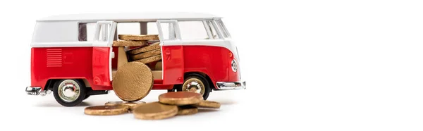 Panoramic shot of toy bus with golden coins on white — Stock Photo