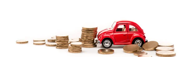 Tiro panorâmico de carro de brinquedo vermelho e moedas de ouro no branco — Fotografia de Stock