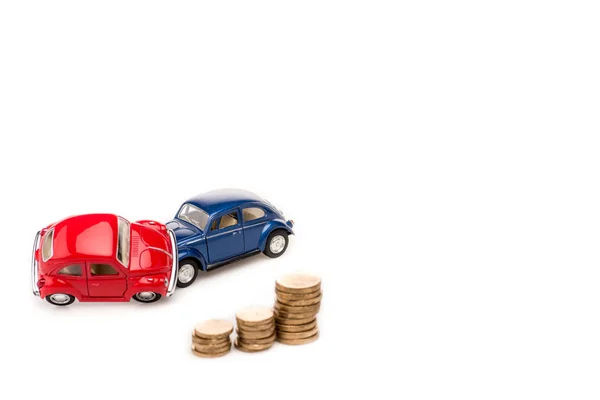 Rouge et bleu jouets voitures et pièces d'or sur blanc — Photo de stock