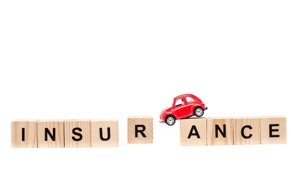 Macchinina rossa su blocchi di legno con lettere isolate su bianco — Foto stock