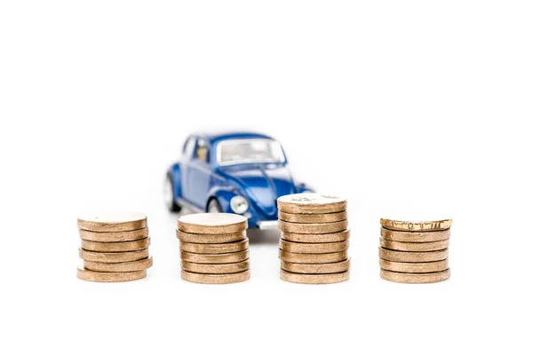 Foco seletivo de moedas e carro de brinquedo azul no branco — Fotografia de Stock
