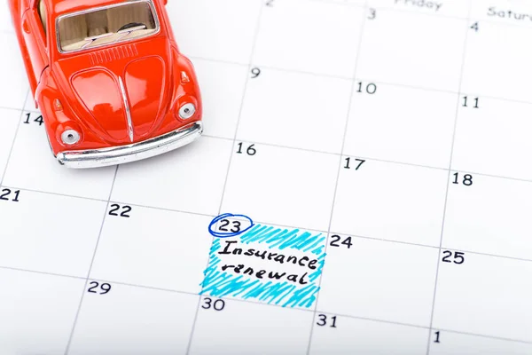 Coche de juguete rojo en el calendario con fecha marcada - foto de stock