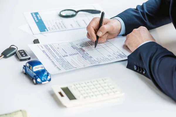 Vista recortada del hombre en el certificado de seguro de firma de desgaste formal - foto de stock