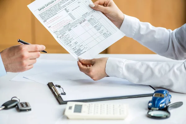 Cropped view of woman in formal wear giving man insurance certificate — Stock Photo