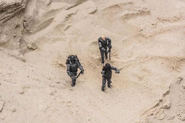 Soldados de brinquedo de plástico na duna de areia com armas — Fotografia de Stock