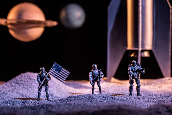 Toy soldiers holding american flag in space near rocket and planets — Stock Photo
